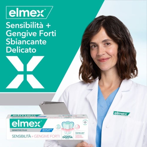Una dottoressa in camice bianco tiene in mano una confezione di dentifricio Elmex "Sensibilità + Gengive Forti Sbiancante Delicato", su uno sfondo bianco e verde con il logo del brand
